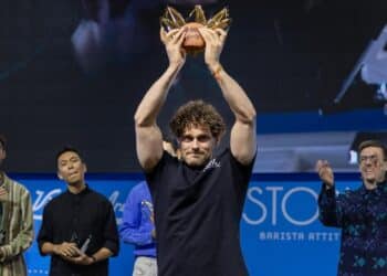 Jack Simpson raises the 2025 World Barista Championship trophy. Image: Axil Coffee Roasters.