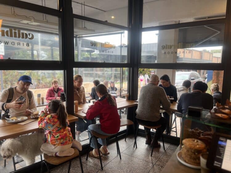 Birdwood’s open layout uses “timeless” dark trims and raw materials like timber, and concrete. Image: Birdwood Café.